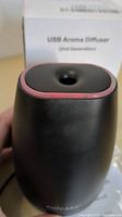 Close-up photo of the black Soicare USB Aroma Diffuser showing the mist outlet with a pink rim on the top, illustrating the product design and condition.