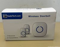 Box showing SadoTech branding and wireless doorbell receiver with two transmitters depicted.