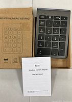 Bluetooth wireless numeric keypad in box with user manual on top, viewed from above showing keypad layout and packaging.