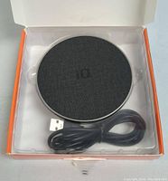 Wireless charging pad in packaging with USB cable visible