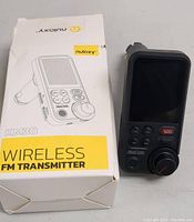 Photo of Nulaxy KM30 FM transmitter device displayed next to the product box showing the front face with LCD screen and control buttons