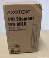 Packaged 6-pack box of Axotexe T10 Filament LED Bulbs, listing key specs including 80+ CRI, 8W, 60W replacement, and 4000K neutral white.