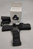 Complete Optex head strap laid out with mounting clip, small accessory pouch and original box showing branding.