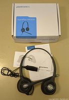 Plantronics SupraPlus HW261N headset displayed outside box with accompanying user manuals.