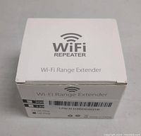 White retail box labeled 'WiFi REPEATER Wi-Fi Range Extender' with model/plu barcodes and specifications.