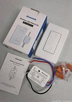 Photo of Dewenwils wireless light switch kit components including switch, receiver, wire connectors, manual and box.
