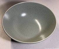 Full view of the stoneware bowl showing its evenly curved interior and rounded lip in sage green color with subtle speckling.