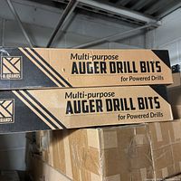 Two cardboard boxes stacked, labeled 'Multi-purpose Auger Drill Bits for Powered Drills' by K-Brands.