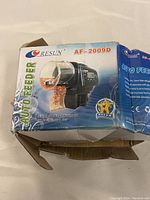 Box of Resun AF-2009D auto feeder with product images and text showing model and usage.