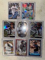 Top view of 8 baseball cards arranged in two rows showing players and holographic designs.