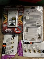 Full view of all items including RIDDEX Pest Repelling Aid, LED Night Light, and incandescent bulbs in packaging and loose.