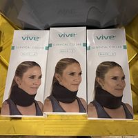 Photo showing the front of three boxed Vive cervical collars with black 4-inch size, worn by a female model.