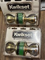 Front view of two Kwikset hall & closet door knobs still in packaging, showing branding and basic product info.