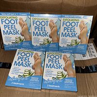 Five unopened boxes of Exfoliating Foot Peel Mask, Aloe Vera variant, neatly arranged showing front packaging and key claims.