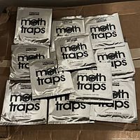 Twelve silver foil packets of Freedom Goods Pantry Moth Traps arranged together, showing the front labels of each packet.