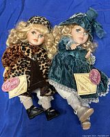 Photo of two collectible Tiffany dolls lying down showing full bodies, attire, and hair details.