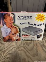 Front side of the box showing Visioneer branding, image of the scanner, and a child with a puppy.