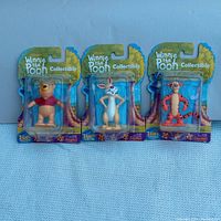 Front view of three Winnie the Pooh collectible figures in original packaging showing Pooh, Rabbit, and Tigger.