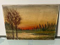 Oil on board landscape painting showing natural scene with trees, water, and sunset sky.