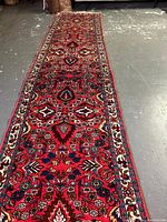 Full-length view of the red runner rug on concrete floor