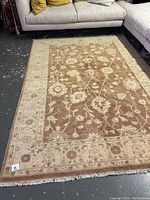 Full view of rug laid flat in showroom under couch