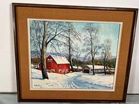 Framed oil on board painting showing a winter landscape with a red barn and covered bridge covered in snow, trees around, signed M.J. Gardiner.