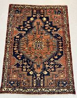 Full view of the hand-knotted wool rug showing the entire design including the large medallion and border.