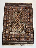 Full view of the rectangular hand knotted Baluch wool rug showing the geometric cross centered motif and border patterns in earth tone colors.
