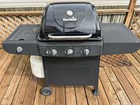 Full view of Char-Broil propane gas grill with side shelves and propane tank attached below