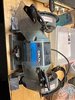 Photo of the Delta 6 inch bench grinder showing motor label, wheels, tool rests and safety guards.