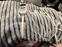 Close-up photo of a soft, plush fabric electric heated lap blanket with ribbed texture and white electrical cord.