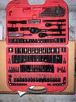 Full open view of the tool set showing ratchets, sockets, bits, and hex keys arranged in red plastic case.