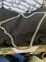 Full view of the silver chain necklace spread out showing overall length and clasp detail.