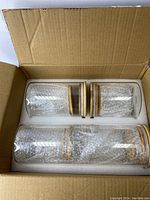 Photo of the glass containers packed in foam in a cardboard box, showing the arrangement and different sizes of the containers.