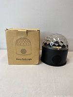 Disco party light with box, showing product label and condition.