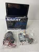 Naifay 7 inch car stereo unit displayed on top of the Naifay box with wiring harness, remote control, and mounting accessories in sealed plastic bags arranged in front.