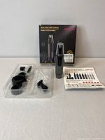 Full lot showing Areyzin box, trimmer, multiple attachments in plastic tray, and instruction manual.