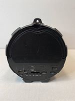 Rear view showing USB, AUX, DC 5V ports, power switch, volume control dial, and buttons for mode and playback.