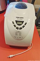 White Black & Decker All-in-One breadmaker with digital controls on red surface