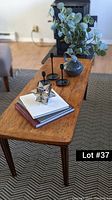 Full view of the coffee table showing worn wood surface and tapered legs on patterned rug.