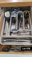 Cutlery pieces organized in a drawer tray, including spoons, forks, knives and other utensils
