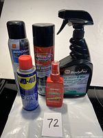 Photo showing five car care products including Simoniz wax, Black Magic wheel cleaner, WD-40 lubricant, BodyPro wash & wax spray, and Meguiar's wax spray.