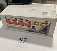 The product in its original box labeled 'Compound Miter Jig' with instructions on use visible on the packaging.