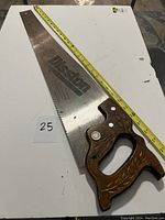 Full view of the Disston hand saw showing the wooden handle and metal blade with Disston branding and length measurement approx 25 inches.