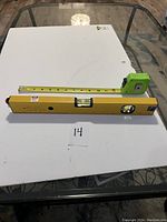 Laser level, tape measure, and standard level laid out on table for size and condition display.