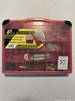 Closed front view showing the Plano label and red organizer case with 27 compartments and miscellaneous hardware visible inside.