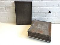 Six rectangular metal printing trays stacked, showing size and condition