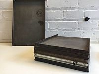 Stack of six printing trays showing front face, metal surface, and various metal tones including aluminum, plus visible markings and stamps.
