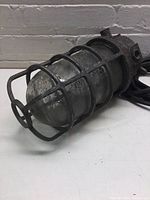 Side view showing metal cage protecting the bulb chamber in a weathered finish