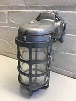 Side view of Rab industrial metal cage light fixture mounted on white wall.